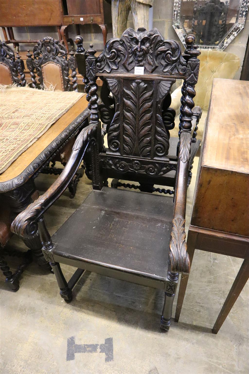 A near pair of Flemish carved oak elbow chairs, larger width 65cm x depth 60cm, height 126cm